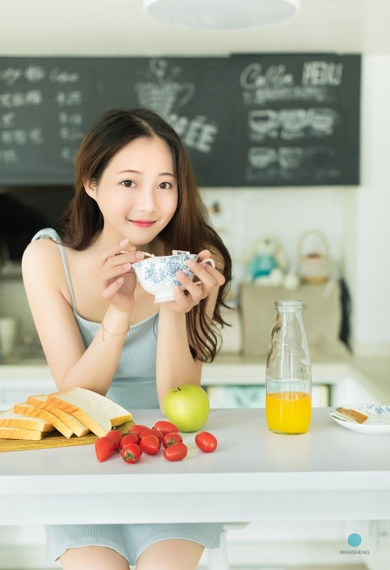 白嫩性感少女蓝色吊带香肩美腿吃早餐写真图片