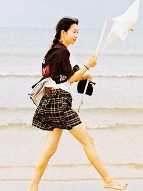 清纯美女学生制服发丝凌乱身姿轻盈海边写真图片