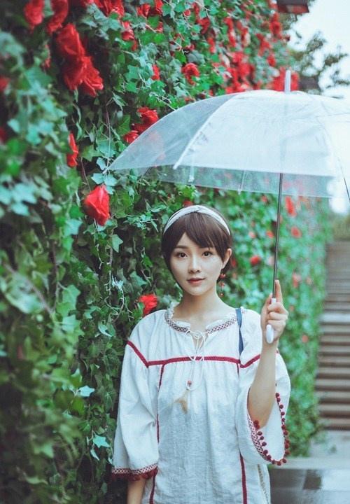 雨天撑伞短发女孩花墙背景小清新写真